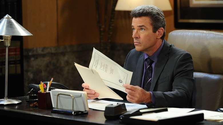 John J. York holding papers during a scene