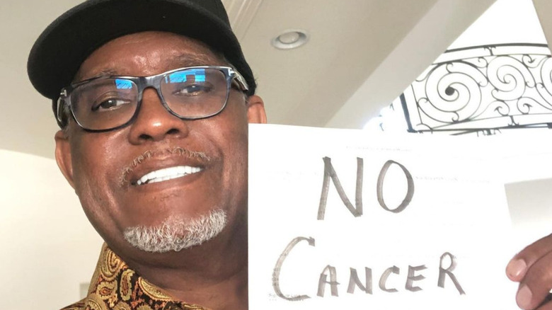 Gregg Leakes with a sign reading "No Cancer"