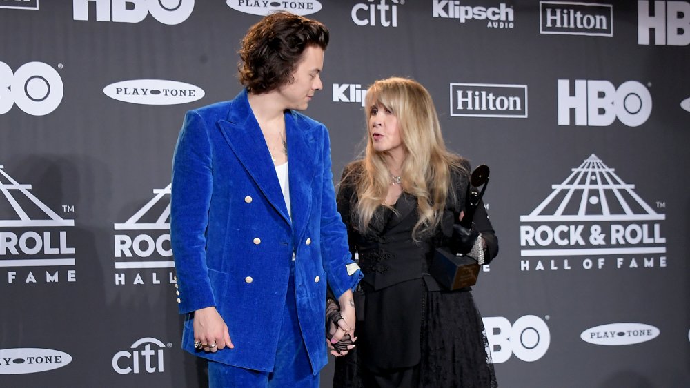 Harry Styles and Stevie Nicks looking at each other and holding hands