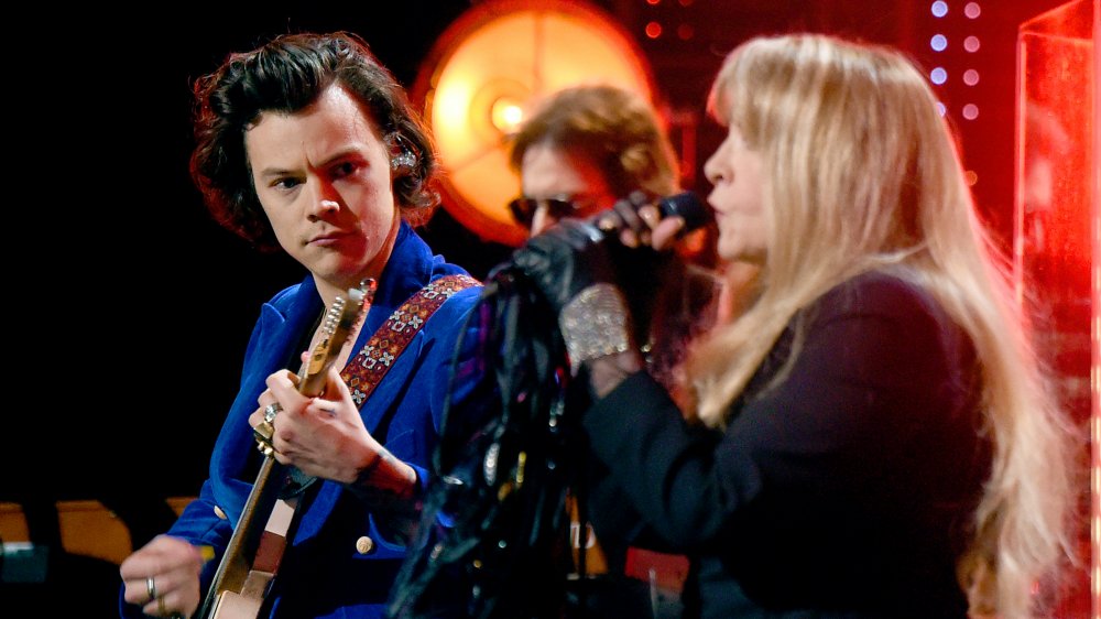 Harry Styles playing guitar and watching Stevie Nicks sing