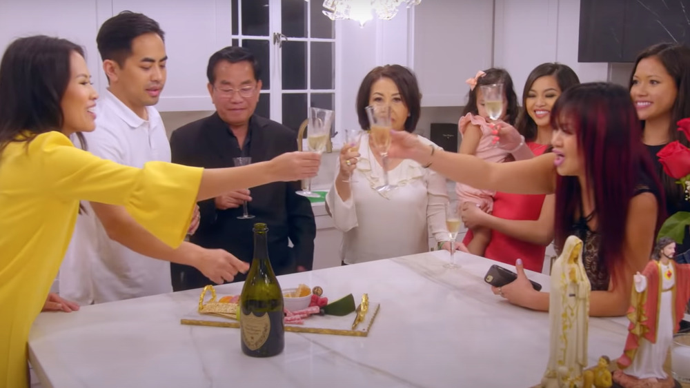 Members of the Ho family toasting in the kitchen