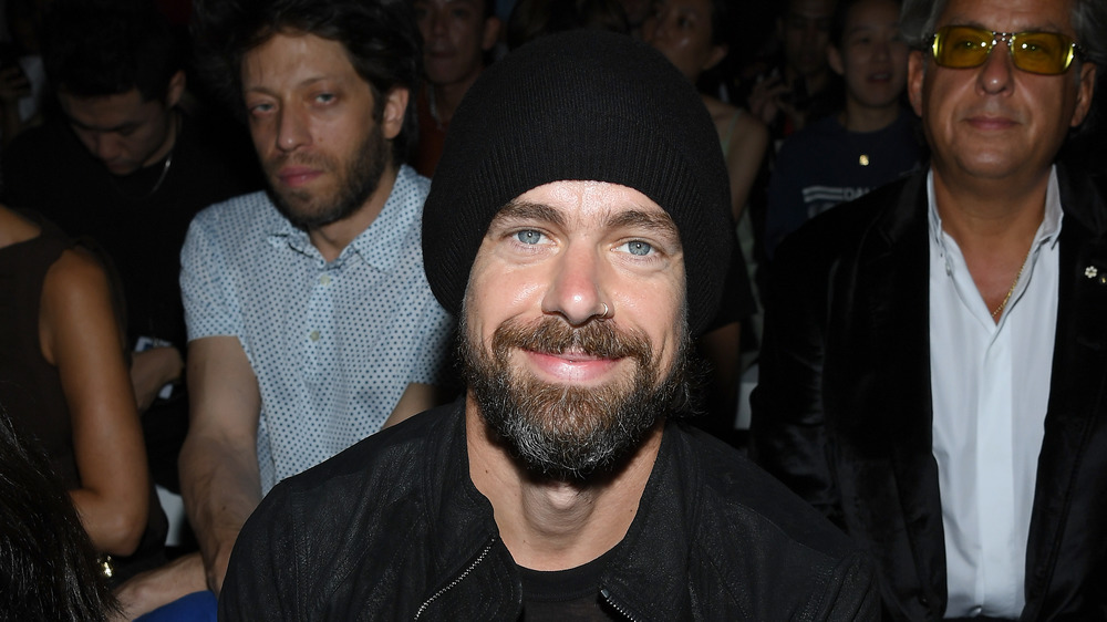 Jack Dorsey smiling and seated at fashion show