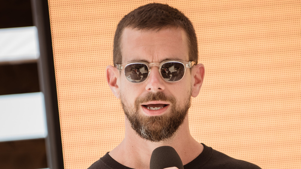 Jack Dorsey speaking into microphone with sunglasses on