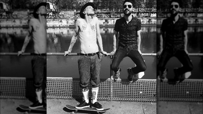 Jamie Campbell Bower on skateboard, posing with friend