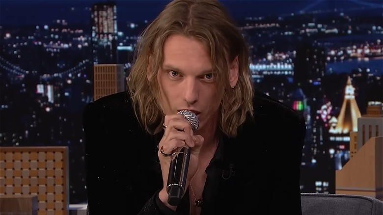 Jamie Campbell Bower talking into a mic