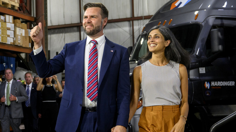 JD and Usha Vance holding hands in warehouse