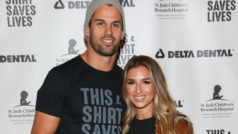 Eric Decker and Jessie James Decker posing together in front of a step-and-repeat