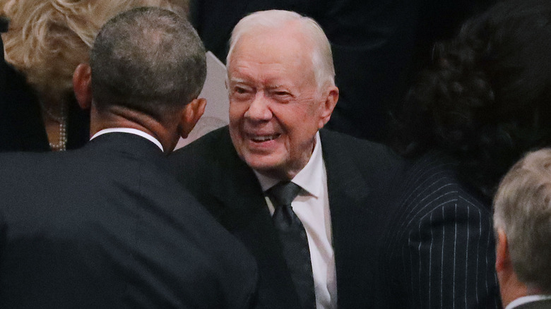 Jimmy Carter smiling at Barack Obama in 2018