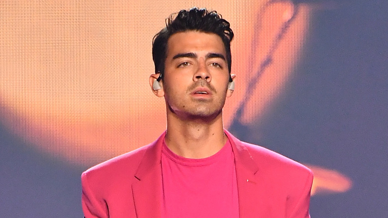 Joe Jonas on stage holding a mic in his hand