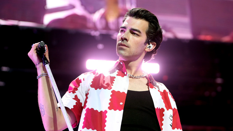Joe Jonas on stage holding a mic in his hand
