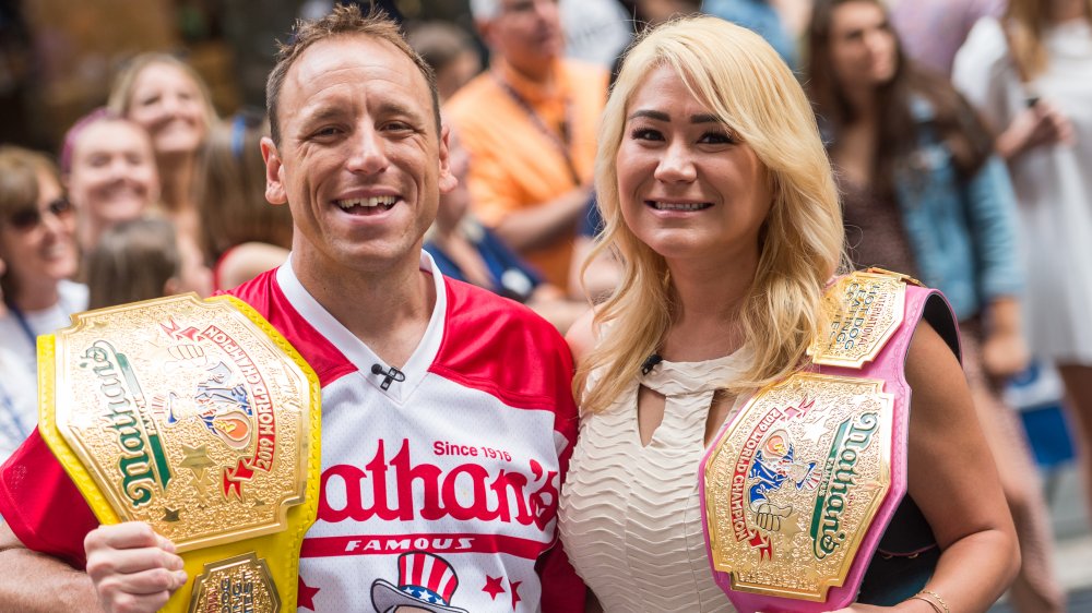 Joey Chestnut, Miki Sudo posing together at a hot dog eating contest