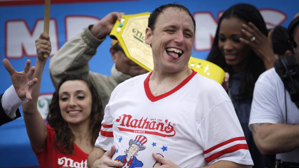 Joey Chestnut laughing while surrounded by fans