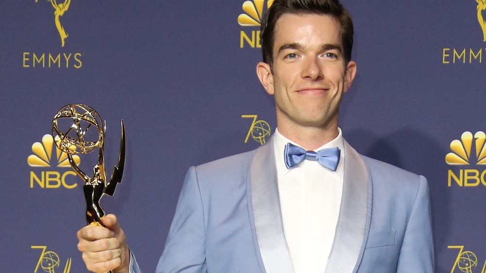 John Mulaney holding his Emmy