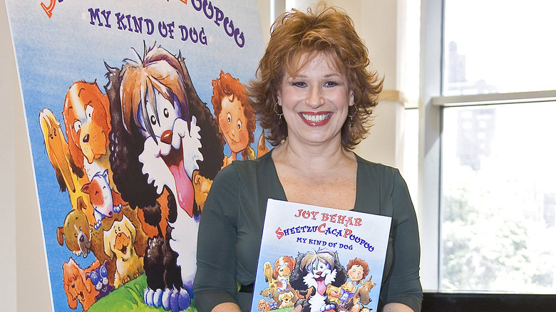 Joy Behar smiling displaying her children's book