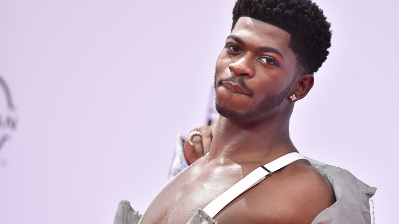 Shirtless Lil Nas X posing and biting lip