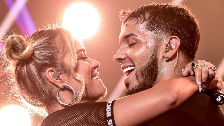 Karol G with her arms around Anuel AA