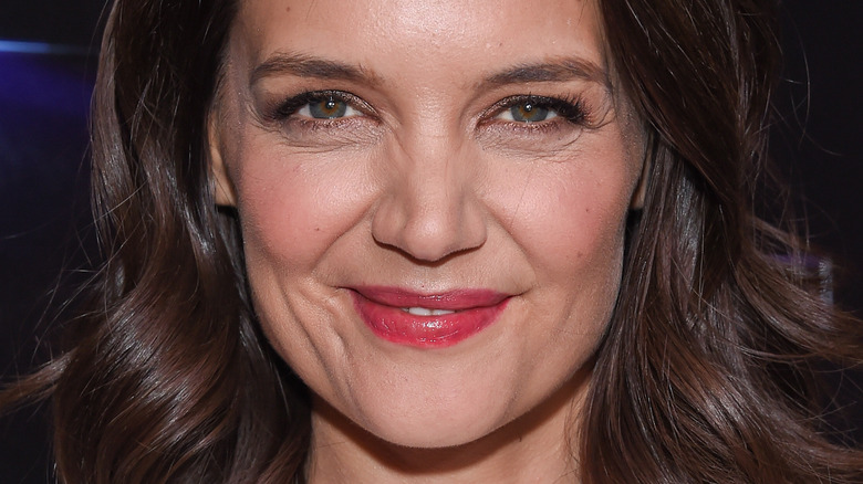 Katie Holmes wearing red lipstick, grinning