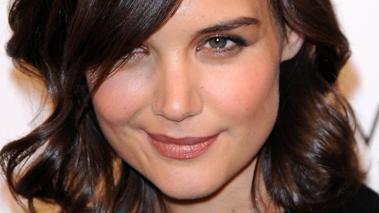 Katie Holmes with her hair covering half her face, smirking