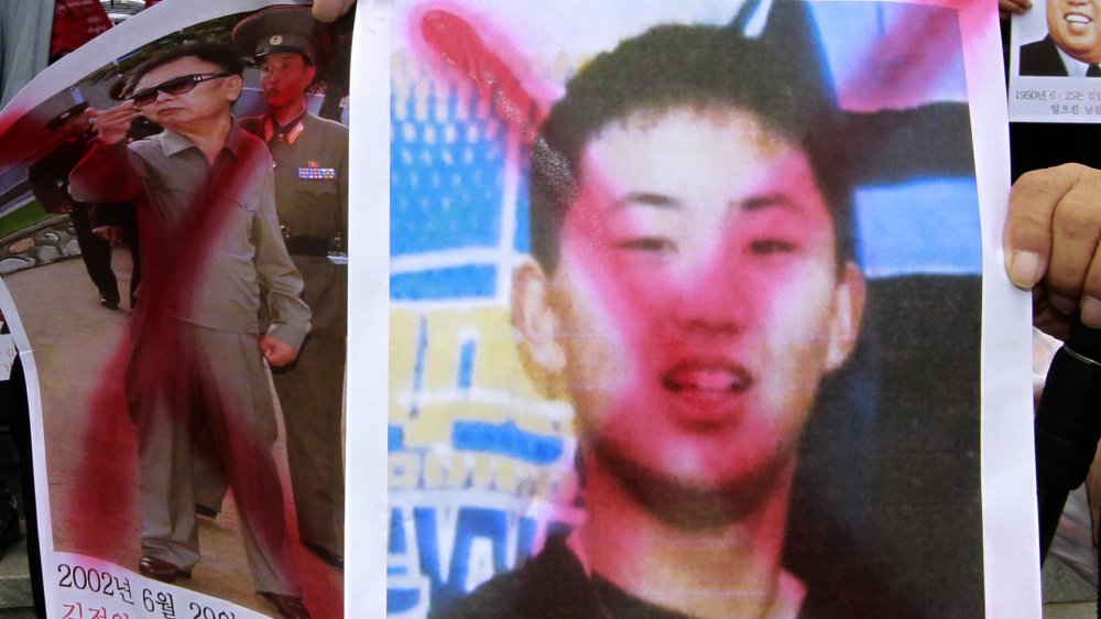 Protester holding picture of young Kim Jong-un