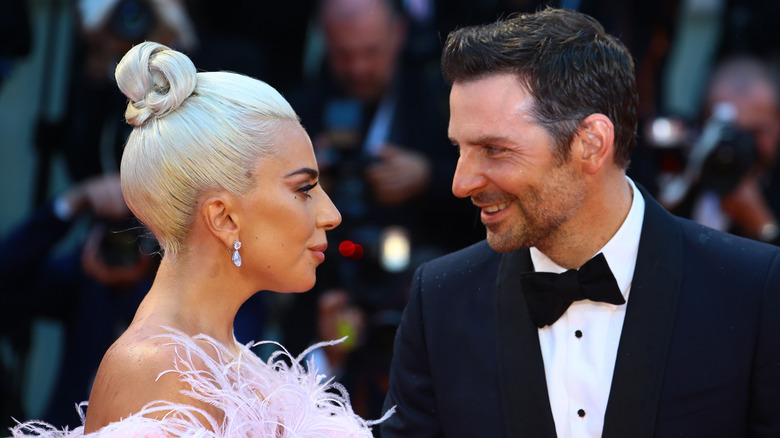 Bradley Cooper smiling at Lady Gaga