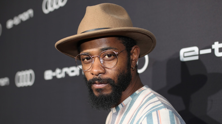 LaKeith Stanfield in glasses and a hat