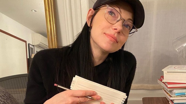 Laura Prepon with a notebook