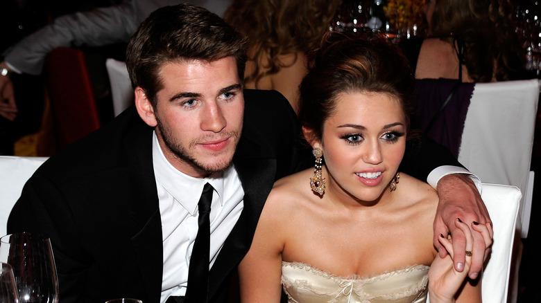 Liam Hemsworth and Miley Cyrus holding hands