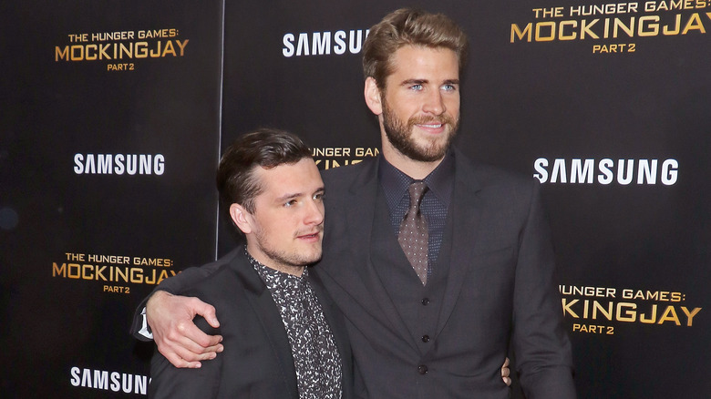 Liam Hemsworth with arm around Josh Hutcherson