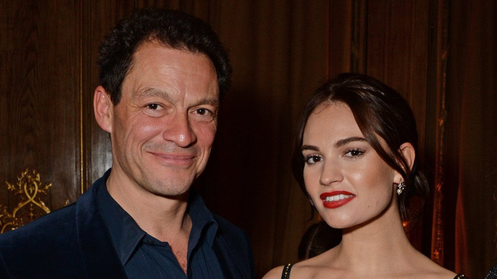 Dominic West and Lily James posing arm in arm