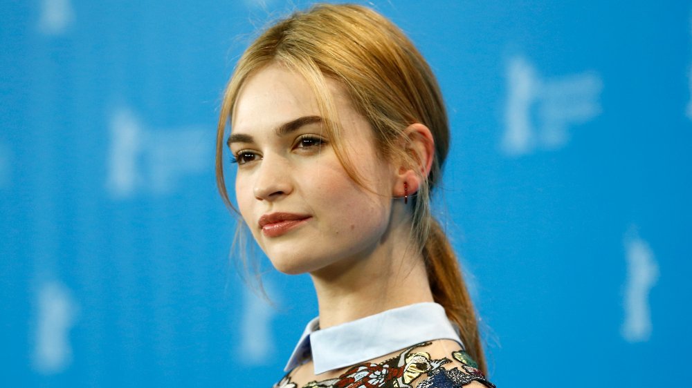 Lily James posing from the side with a neutral expression