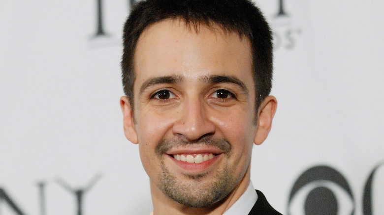 Lin-Manuel Miranda holds up an award