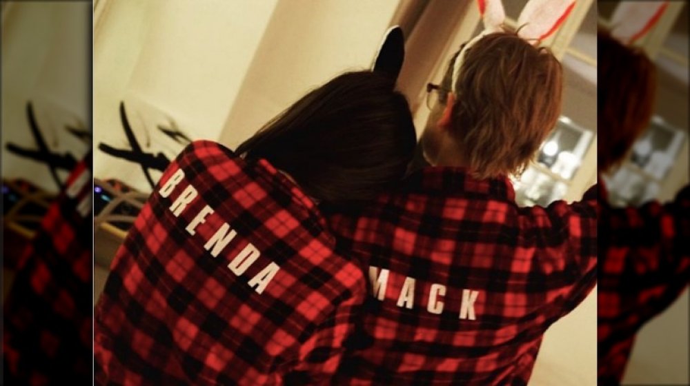 Brenda Song and Macaulay Culkin from the back, wearing matching plaid pajamas