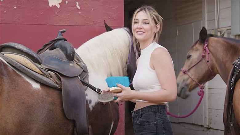 Madelyn Cline brushing horses