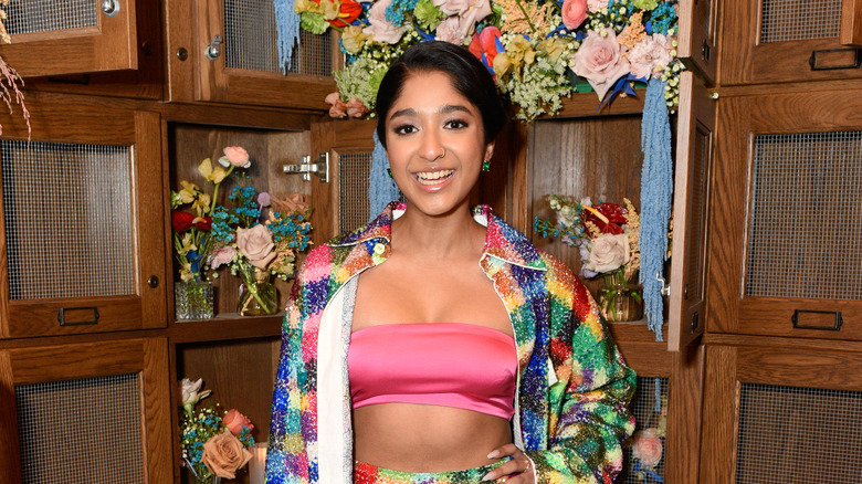 Maitreyi Ramakrishnan posing in 2022, in front of flowers