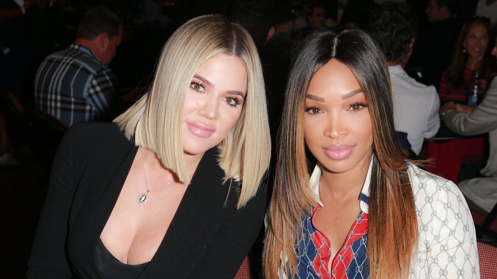 Khloe Kardashian and Malika Haqq seated and smiling at event