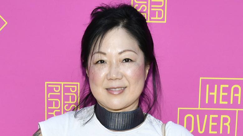 Margaret Cho smiling in front of pink background