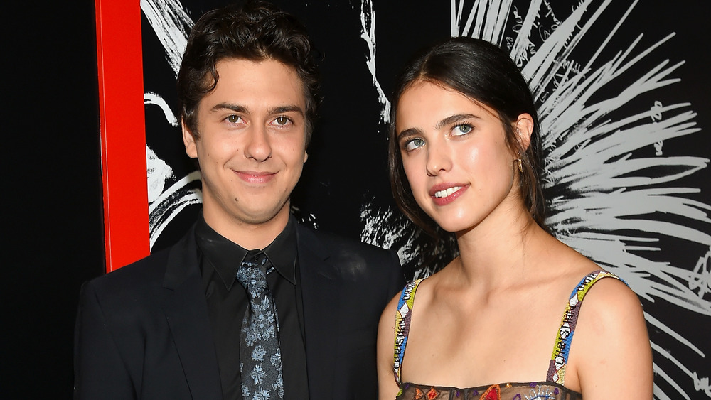 Nat Wolff and Margaret Qualley smiling together at a premiere 