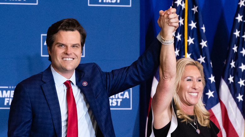 Matt Gaetz holding hands with Marjorie Taylor Greene at an event