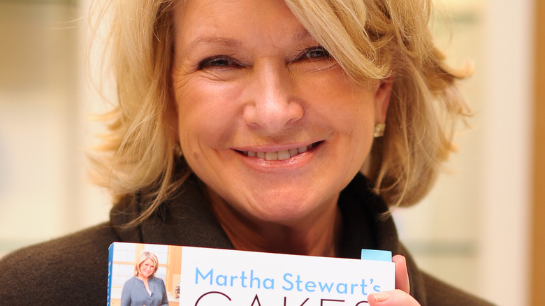 Martha Stewart holding her book, smiling