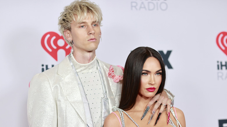 Machine Gun Kelly with his arm around Megan Fox