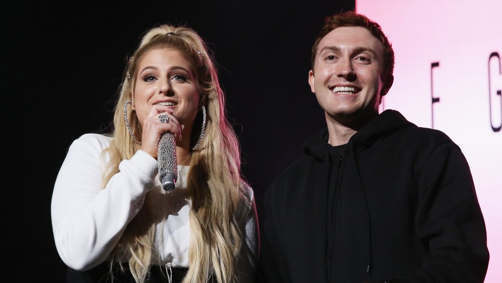 Meghan Trainor speaking into microphone with Daryl Sabara next to her