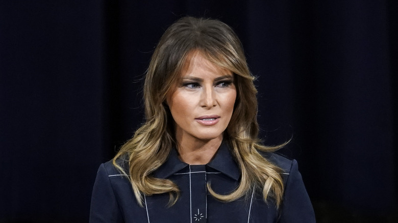 Melania Trump posing in navy dress