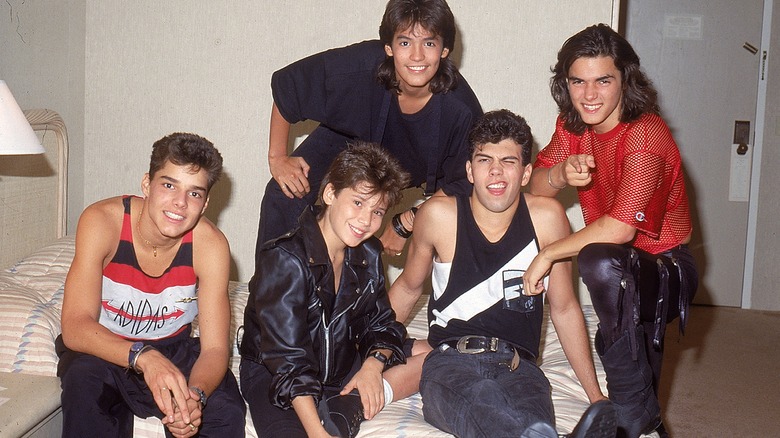 Young Menudo members posing together 