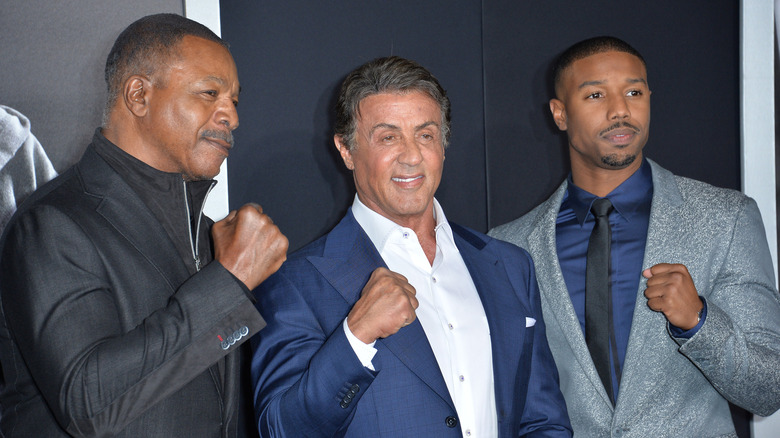 Michael B. Jordan with Carl Weathers and Sylvester Stallone, punching one hand