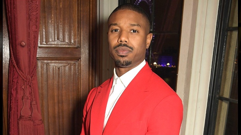 Michael B. Jordan  posing in red suit