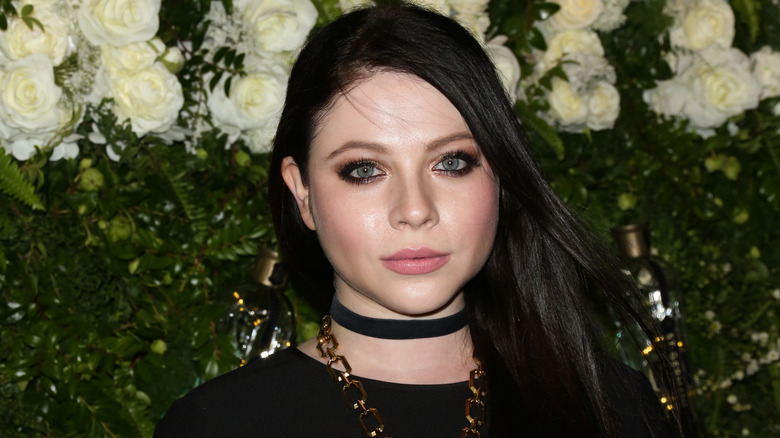 Michelle Trachtenberg posing in front of flowers in 2017