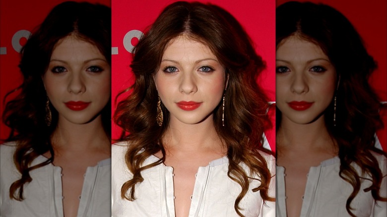 Michelle Trachtenberg posing in front of a red background