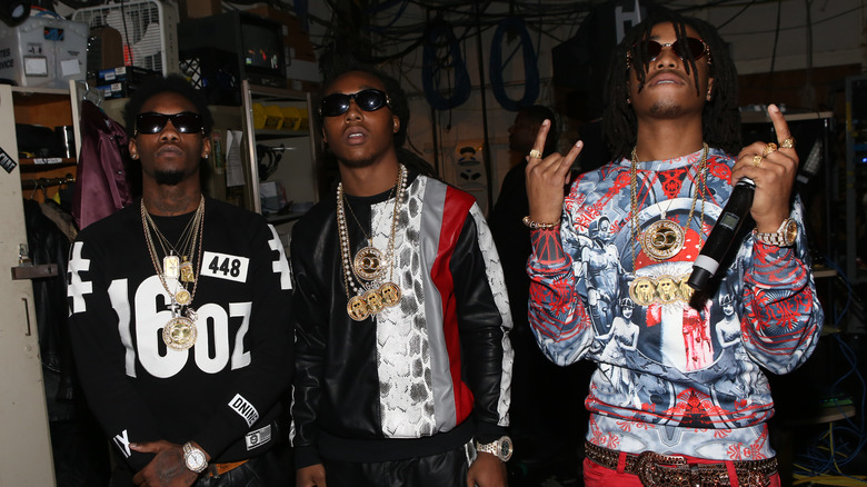 Migos posing together at an event