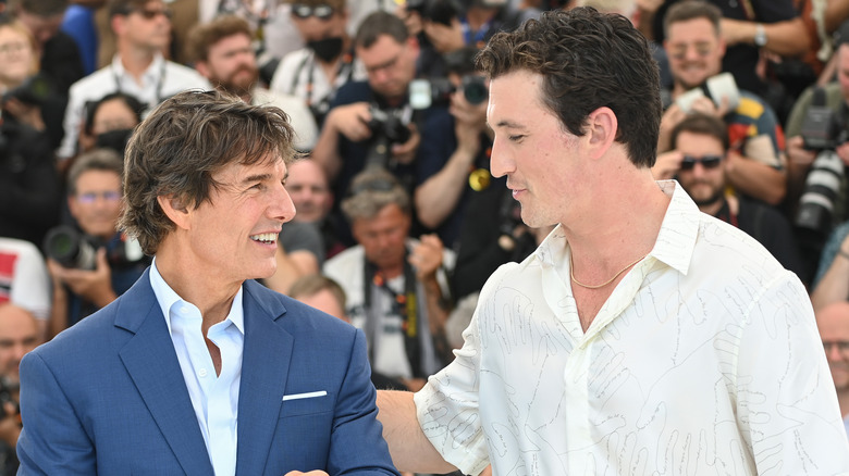 Tome Cruise and miles Teller laughing