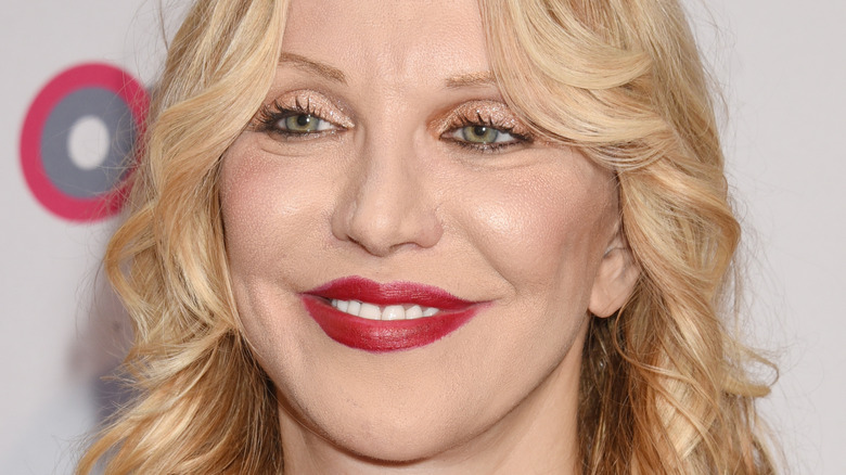 Courtney Love smiling on red carpet